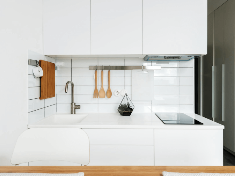 Modern compact kitchen design with white cabinets, a sleek countertop, and minimalistic decor, showcasing efficient use of space for small kitchens.