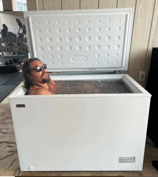Jason Momoa taking an ice bath in a fridge