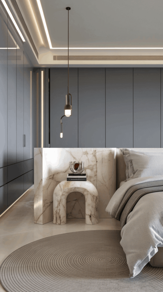 Luxurious bedroom with a sculptural marble bedside table in an arch shape, styled with books and decor against dark built-in wardrobes.