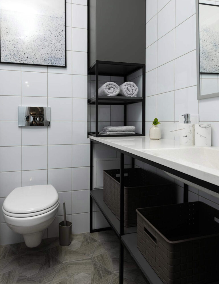 A modern bathroom with an open under-sink shelf, displaying large black storage baskets and rolled towels for practical organization in a small space. Many bathroom storage ideas for small spaces are visible!