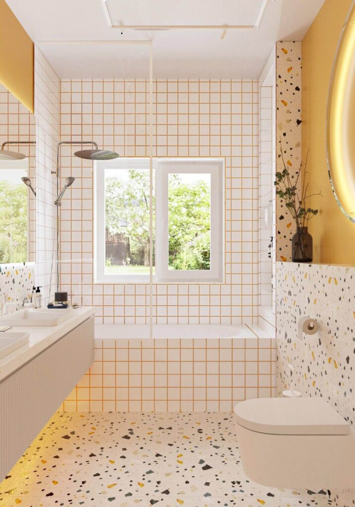 Bright and modern bathroom featuring white subway tiles with warm yellow grout, terrazzo floor, floating vanity, and a large window filling the space with natural light.