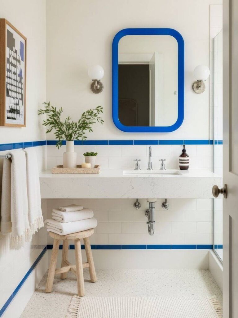 White bath with blue border and mirror makes smart use of small bathroom color ideas, merging fresh Bathroom Color Schemes and on-trend color inspiration.