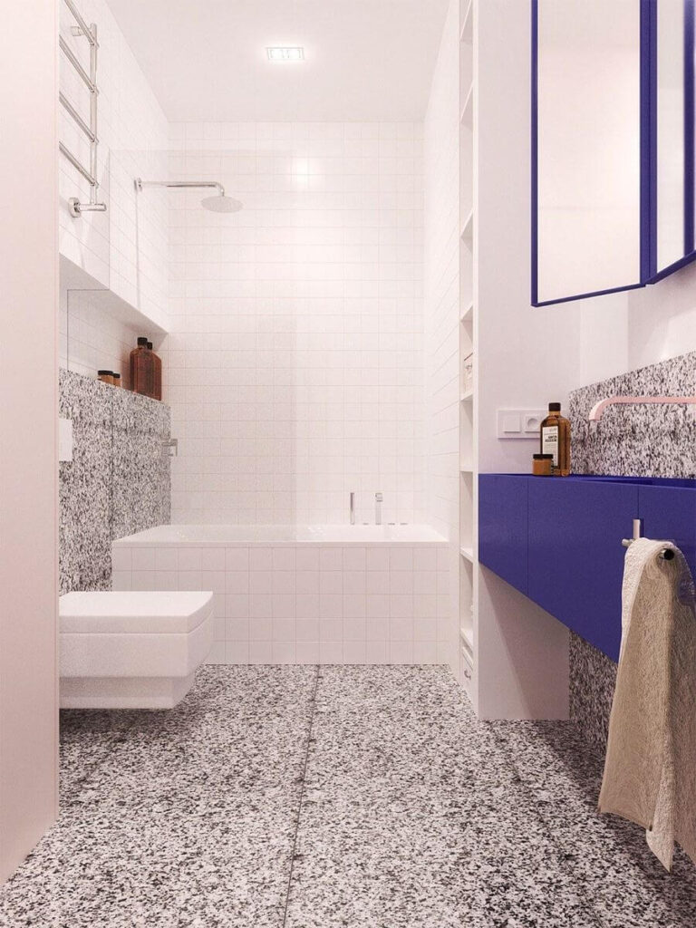 Long view of cobalt blue vanity and bold terrazzo in a bright white bath, featuring creative small bathroom color ideas and modern, eye-catching bathroom color schemes.