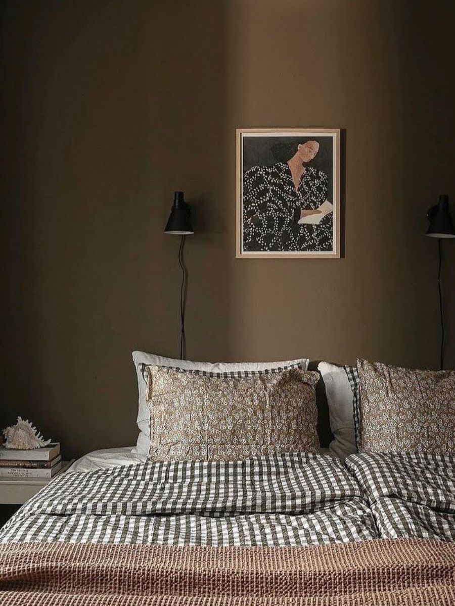Small bedroom with a wall-mounted lamp above the bed.
