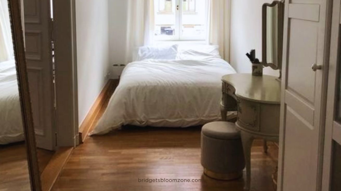 A narrow bedroom with a double bed, placed under the window.