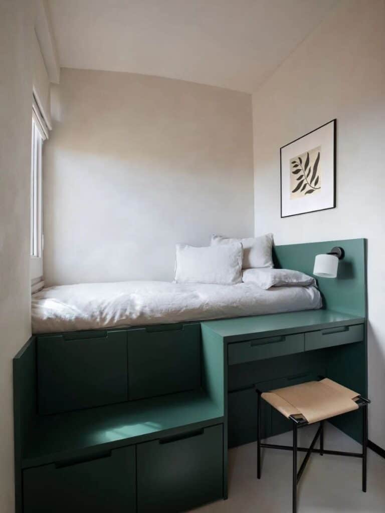 Under-bed storage drawers in a small bedroom — storage integrated into the bed frame. This is a costum design in jade green.