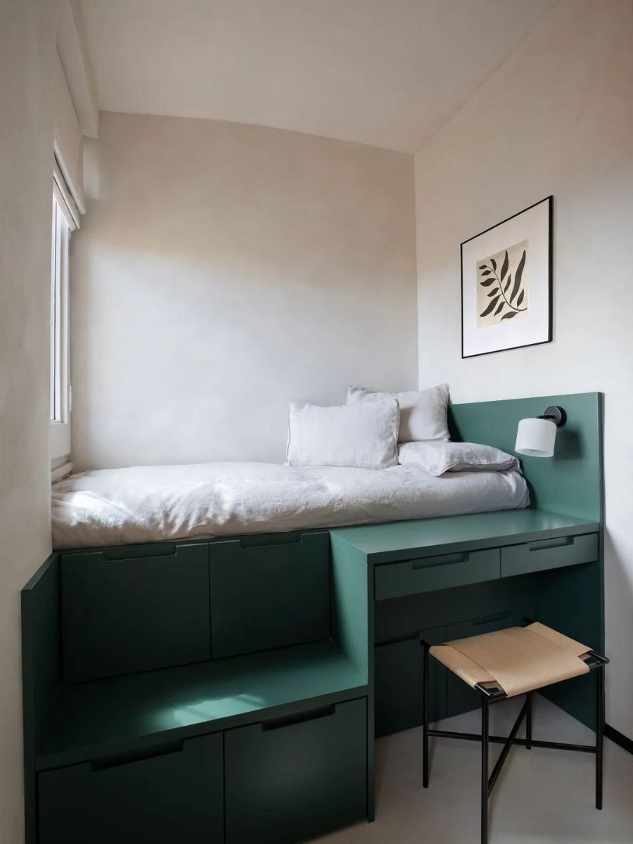 Under-bed storage drawers in a small bedroom — storage integrated into the bed frame. This is a costum design in jade green.
